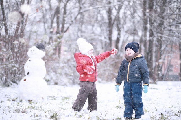 I bambini camminano nel parco con la prima neve