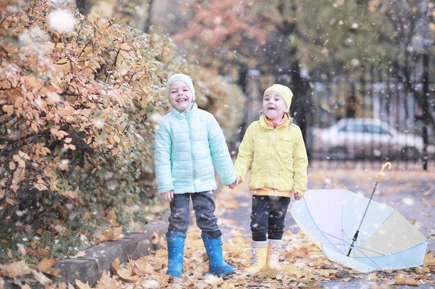 I bambini camminano nel parco con la prima neve