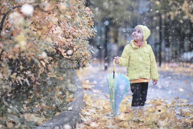 I bambini camminano nel parco con la prima neve