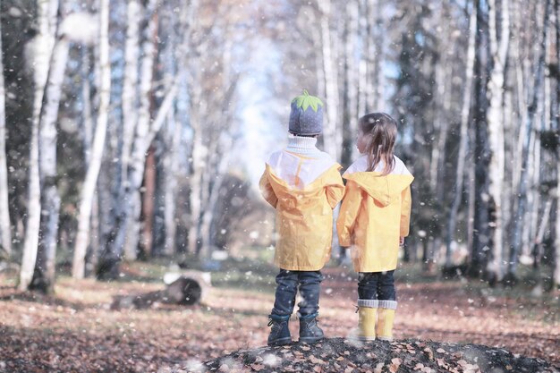 I bambini camminano nel parco con la prima neve