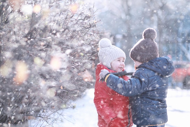 I bambini camminano nel parco con la prima neve