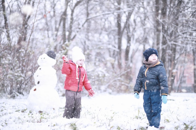 I bambini camminano nel parco con la prima neve