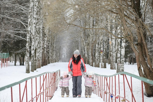 I bambini camminano nel parco in inverno. Famiglia della foresta invernale con bambini a passeggio. Una fredda giornata invernale è una passeggiata in famiglia.