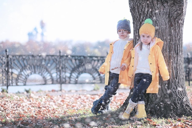 I bambini camminano nel parco prima neve