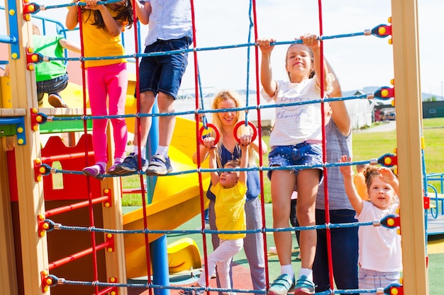 I bambini con le mamme riposano attivamente in un nuovo parco giochi