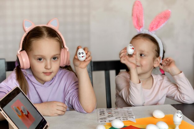 i bambini decorano manichini di uova bianche, attaccano adesivi con diverse emozioni