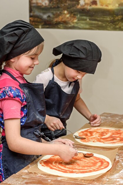 I bambini della pizza e il concetto di cucinare i bambini fanno la pizza