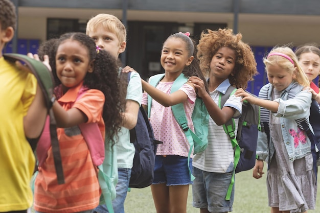 I bambini della scuola stanno in fila al cortile della scuola