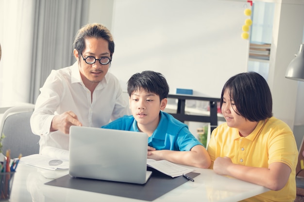 I bambini della stanza del tutor nell&#39;apprendimento della classe sul computer portatile