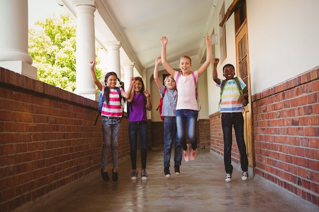 I bambini delle scuole che corrono nel corridoio della scuola