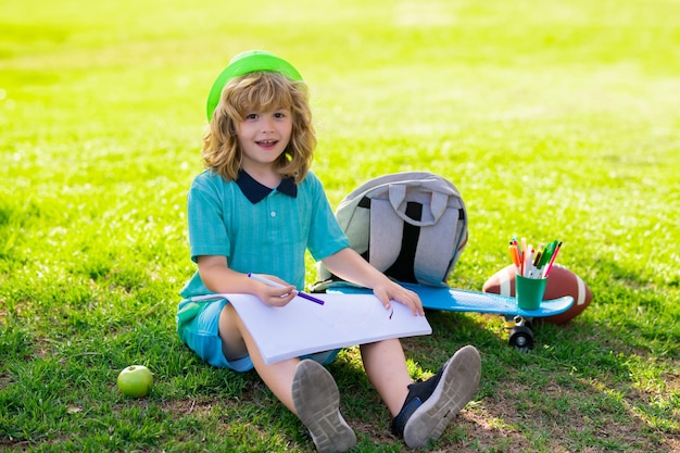 I bambini delle scuole che disegnano nell'arte della pittura del parco estivo il piccolo pittore disegna immagini all'aperto