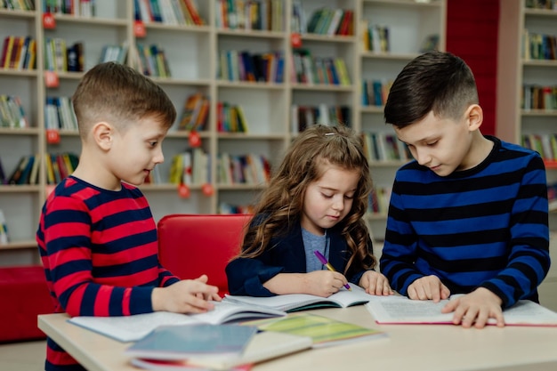 I bambini delle scuole in biblioteca leggono libri, fanno i compiti, preparano un progetto scolastico per le lezioni