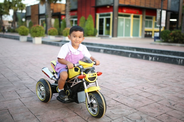 I bambini di asilo che guidano i motocicli per bambino dentro nel parco.