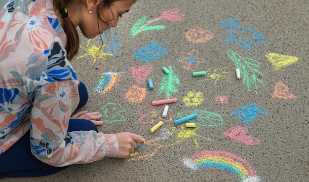 I bambini disegnano con il gesso sul marciapiede Fuoco selettivo