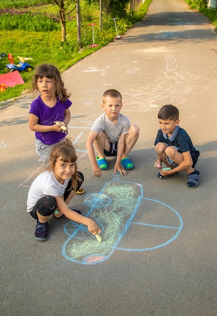 I bambini disegnano un'auto con il gesso sul marciapiede. messa a fuoco selettiva. natura.