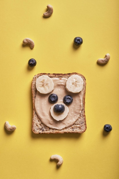 I bambini divertenti portano toast con burro di noci per colazione