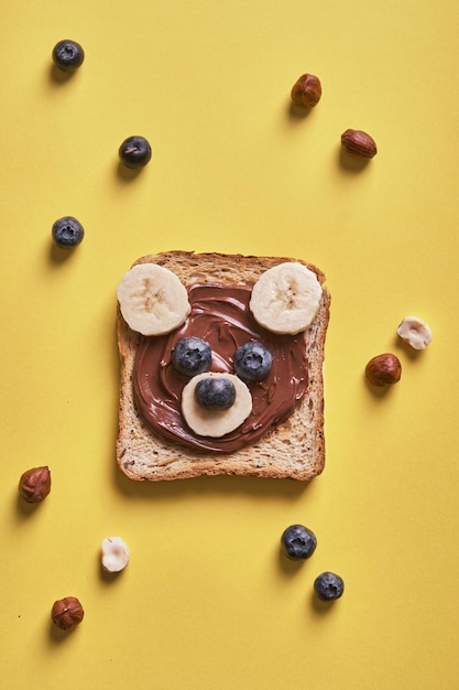 I bambini divertenti portano toast con burro di noci per colazione