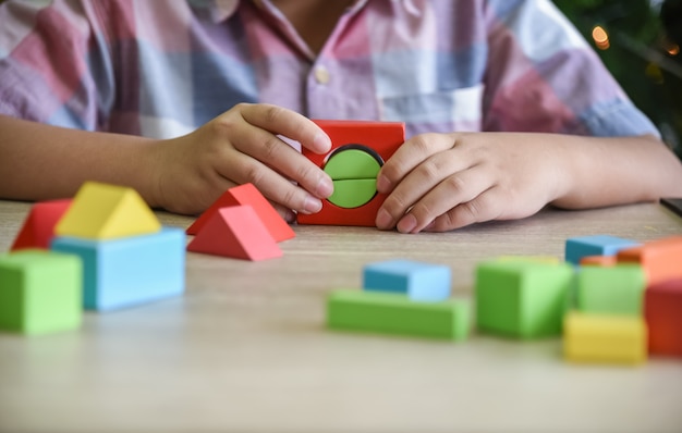 I bambini esercitano le abilità assemblando parti in legno, geometria.