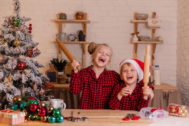 I bambini felici cuociono i biscotti di Natale a casa in cucina