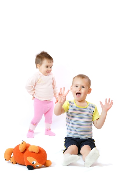 I bambini felici giocano con l'orsacchiotto di peluche.