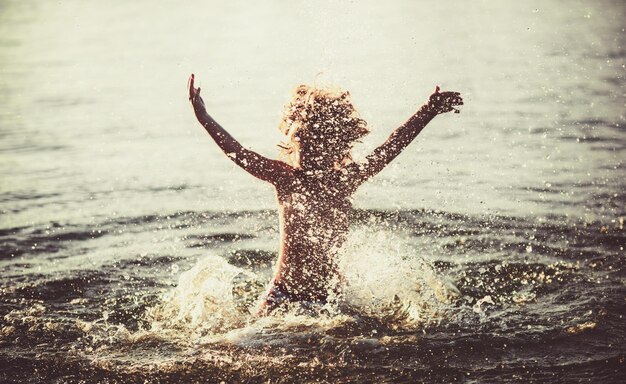 I bambini felici giocano nel mare