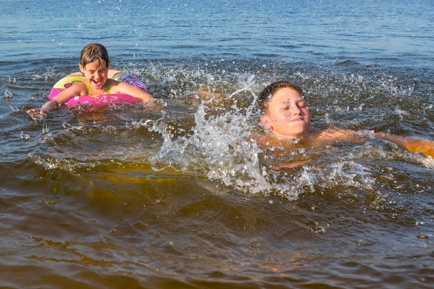 I bambini felici giocano nell'acqua in uno stile di vita di una giornata di sole