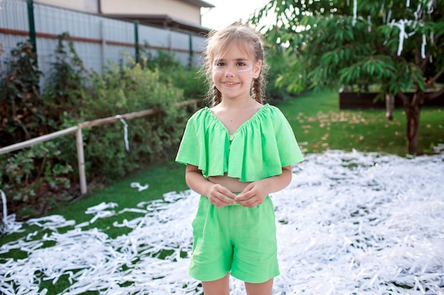 I bambini felici si godono lo spettacolo di carta durante la festa di compleanno all'aperto del cortile in giardino