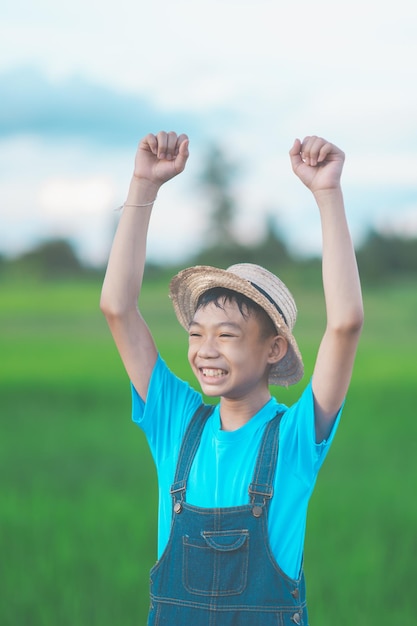 I bambini felici sorridono e piantano l'albero in campagna