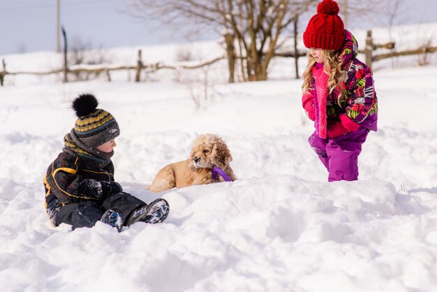 I bambini giocano con cocker spaniel in inverno