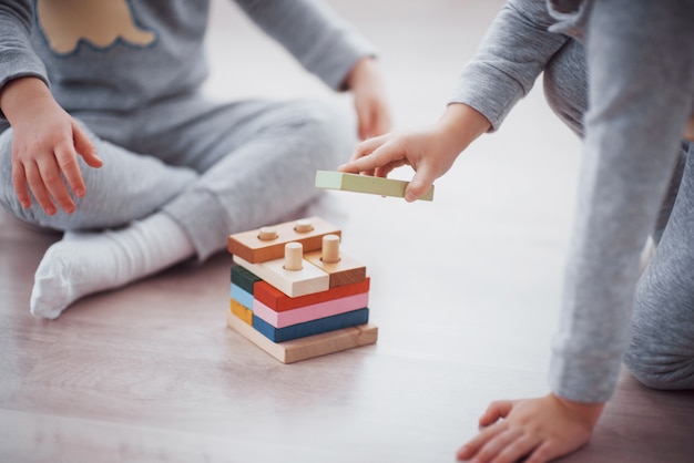 I bambini giocano con un designer di giocattoli sul pavimento della stanza dei bambini.