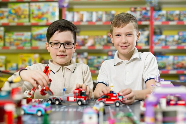 I bambini giocano nel designer al tavolo. Due ragazzi giocano insieme con blocchi di plastica colorati nel centro giochi, a scuola.