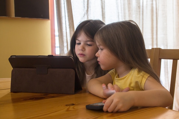 i bambini giocano sul tablet e guardano i cartoni animati