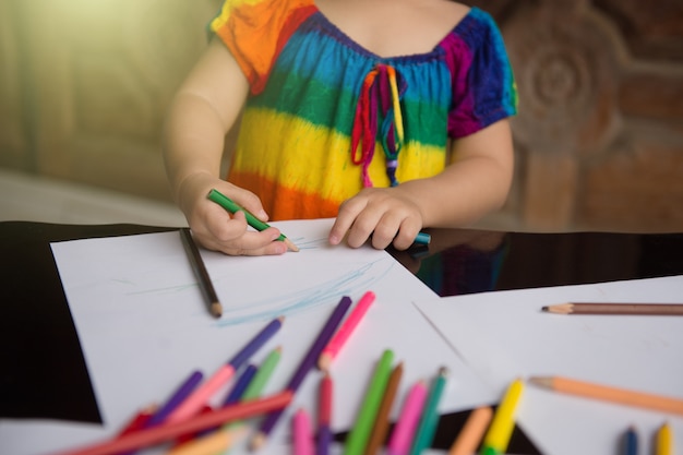 I bambini imparano a disegnare e dipingere con vari colori a matita e carta bianca