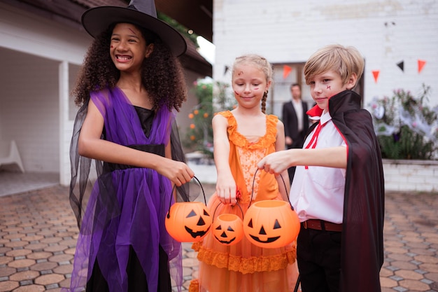 I bambini in costumi di fantasmi si divertono a fare trucchi a Halloween.