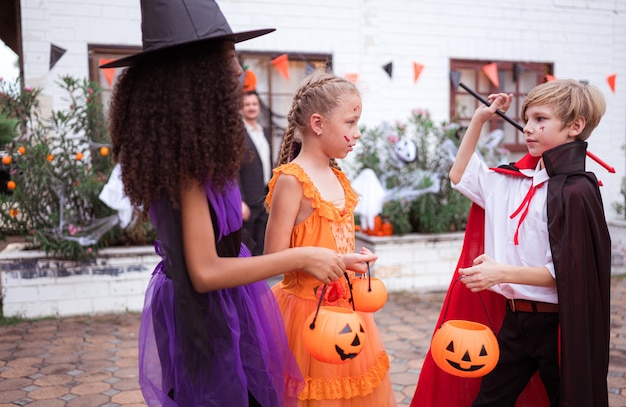 I bambini in costumi di fantasmi si divertono a fare trucchi a Halloween.