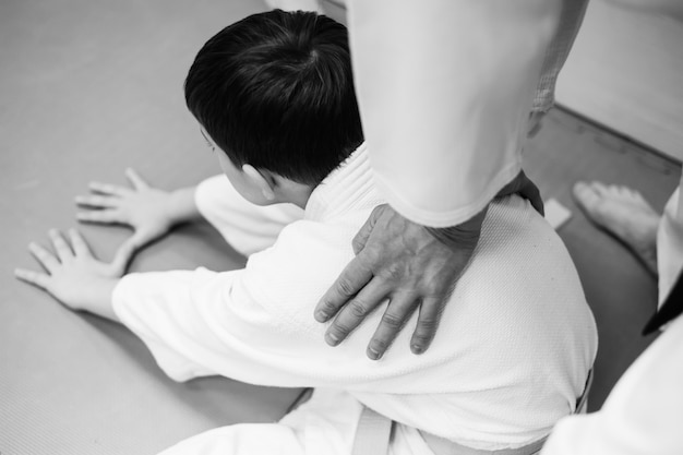 I bambini in kimono iniziano ad allenarsi sull'aikido.