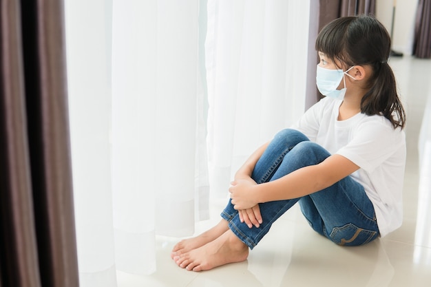 I bambini in maschera medica rimangono in isolamento a casa per l'autoquarantena