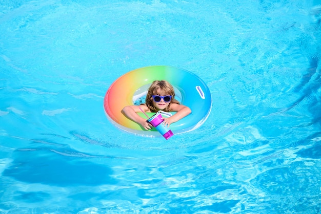 I bambini in piscina si rilassano nuotando sull'anello gonfiabile e si divertono in acqua durante le vacanze estive blu acqua sfondo spazio copia Panorama onda blu del mare