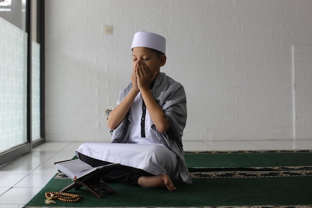 I bambini musulmani pregano pacificamente e silenziosamente nel concetto di Ramadan Kareem della moschea