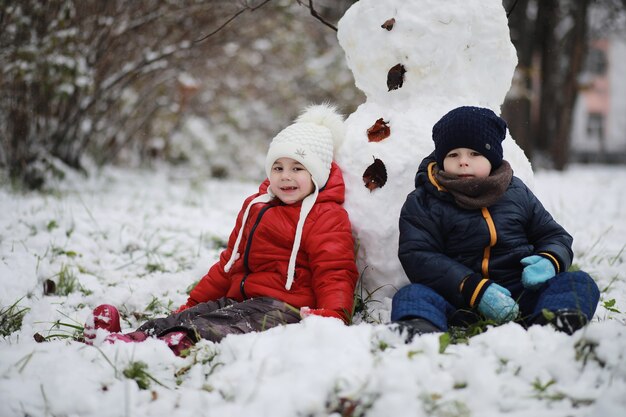 I bambini nel parco invernale giocano con la neve