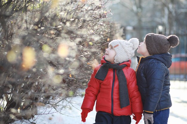 I bambini nel parco invernale giocano con la neve