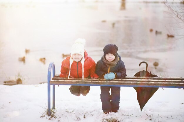 I bambini nel parco invernale giocano con la neve