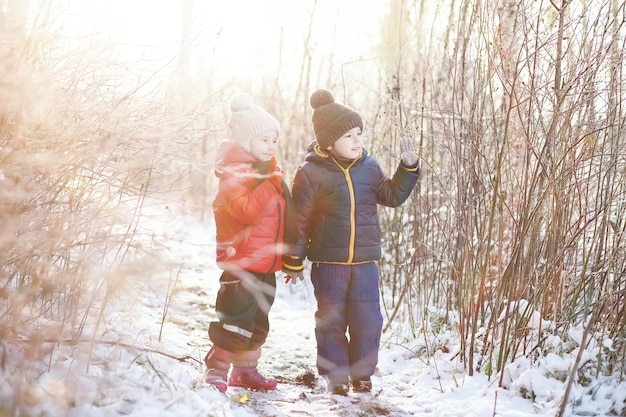 I bambini nel parco invernale giocano con la neve