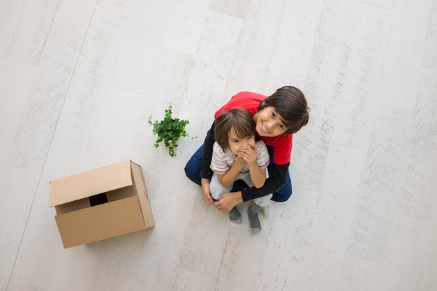 I bambini nella nuova casa si spostano sulla vista superiore del pavimento