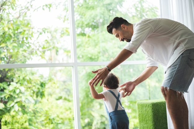 I bambini piccoli con il primo gradino a piedi con le scale a casa, i bambini piccoli sono felici di giocare e imparano a gattonare con la famiglia, un neonato carino che si diverte e si prende cura dell'infanzia