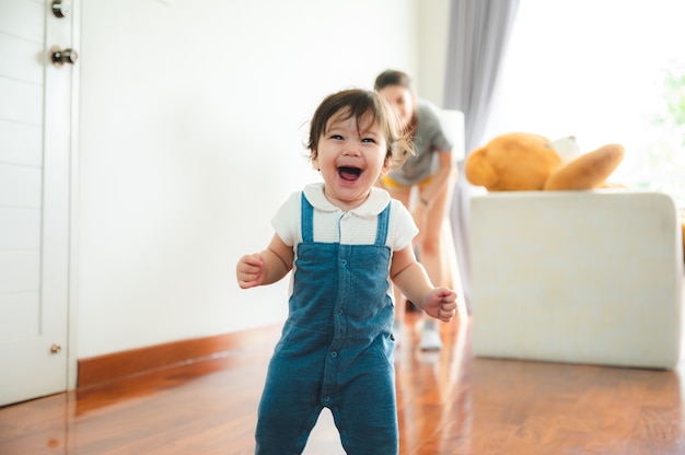 I bambini piccoli con il primo gradino a piedi con le scale a casa, i bambini piccoli sono felici di giocare e imparano a gattonare con la famiglia, un neonato carino che si diverte e si prende cura dell'infanzia