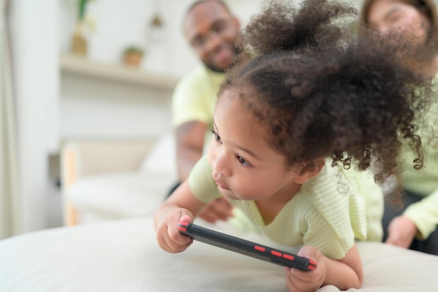 I bambini piccoli giocano e imparano cose nel vasto mondo sul tablet con i genitori a supervisionare