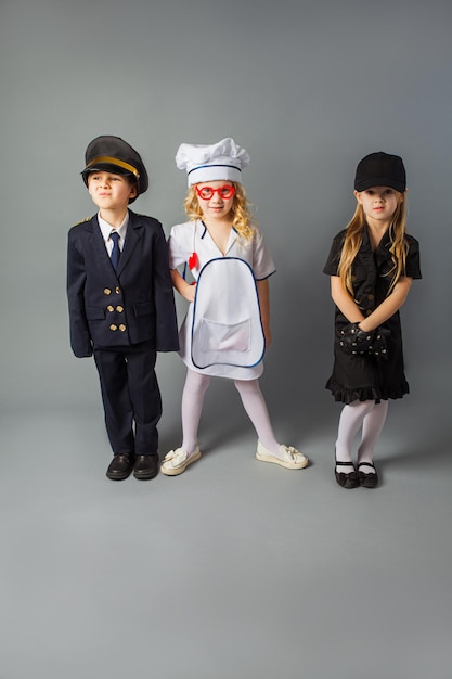 I bambini piccoli posano nei costumi di diverse professioni