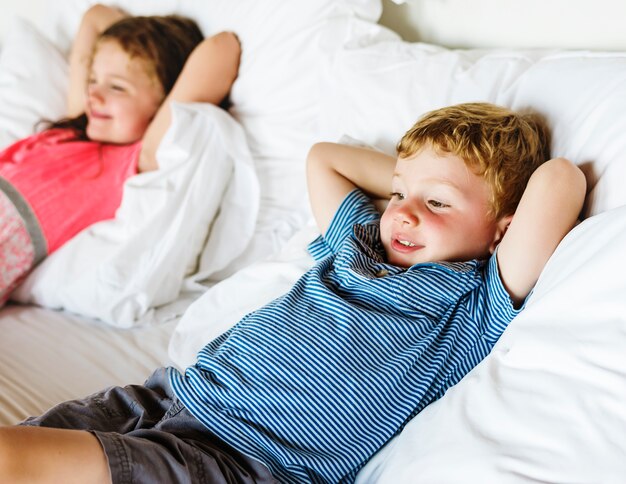 I bambini piccoli sdraiati sul letto