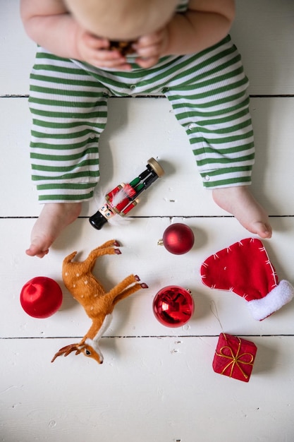 I bambini prima festa di Natale che giocano con i giocattoli festivi su un pavimento di legno